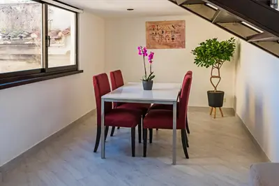 a dining room with a white table and red chairs at Erida Apartment Spanish Steps in Rome