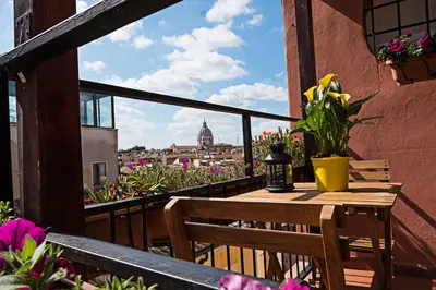 a table and chairs on a balcony with a view of the city at Erida Apartment Spanish Steps in Rome