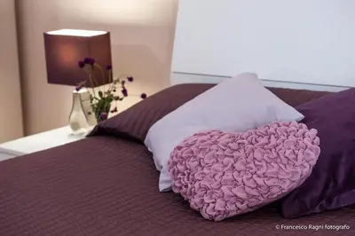 a pink heart pillow sitting on top of a bed at B&B St. Peter's Suites in Rome