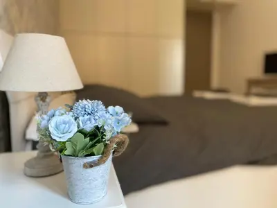 a vase of blue flowers on a table with a lamp at A Quattro Passi Da in Rome