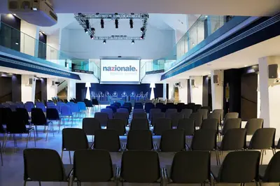 a room with chairs and a stage with a screen at Rome Life Hotel in Rome