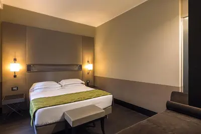 a hotel room with a bed and a chair at Rome Life Hotel in Rome