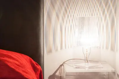 a lamp on a glass table next to a bed at Domus Fabiola - Vaticano in Rome
