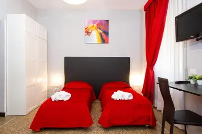 a room with two red pillows and a table and a desk at Domus Fabiola - Vaticano in Rome