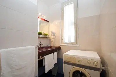 a bathroom with a sink and a washing machine at Domus Fabiola - Vaticano in Rome