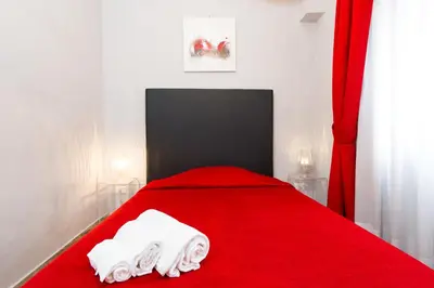 a bedroom with a red bed with towels on it at Domus Fabiola - Vaticano in Rome