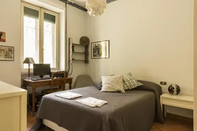 a bedroom with a bed and a desk with a computer at Lemon Tree Apartment Sistine Chapel in Rome