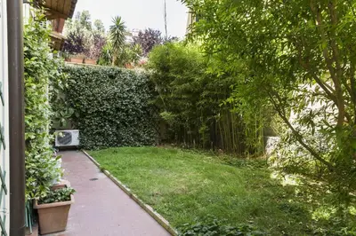 a garden with a green hedge and a walkway at Lemon Tree Apartment Sistine Chapel in Rome