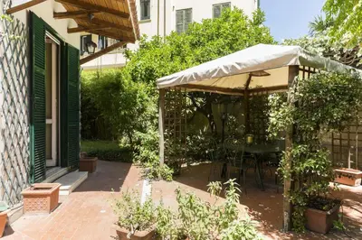 a patio with a table and an umbrella at Lemon Tree Apartment Sistine Chapel in Rome
