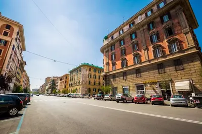 a city street with cars parked on the side of the road at I Prati Di Roma in Rome