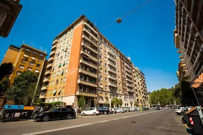 a tall building on a city street with parked cars at I Prati Di Roma in Rome