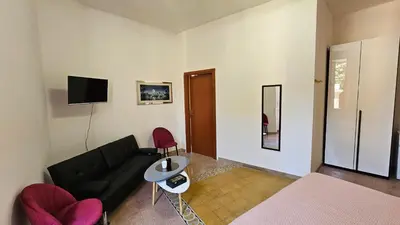 a bedroom with a bed and a couch and a tv at B&B Piazza Ragusa in Rome