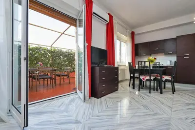 a kitchen and dining room with red curtains and a table at Holiday rental St Peter's area in Rome