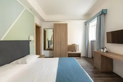 a hotel room with a bed and a television at Fleming Suites by Hili in Rome