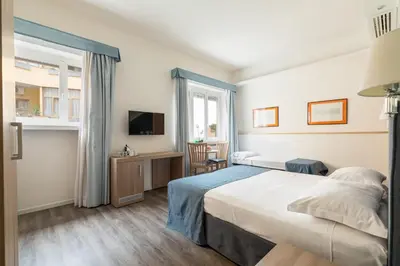 a hotel room with a bed and a tv at Fleming Suites by Hili in Rome