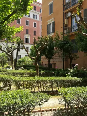 a park with trees and bushes in front of a building at Alex Place in Rome