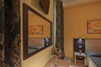 a room with a mirror and a bed and a table at Alex Place in Rome