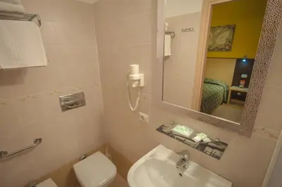 a bathroom with a sink and a toilet and a mirror at Alex Place in Rome