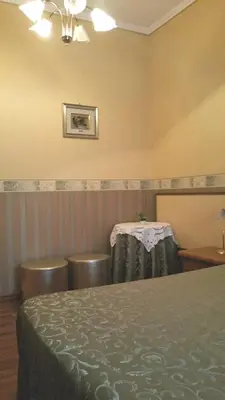 a room with a bed and two chairs and a table at Petite Maison in Rome