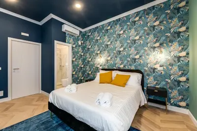 a bedroom with a bed with a floral wallpaper at Suri Suites in Rome