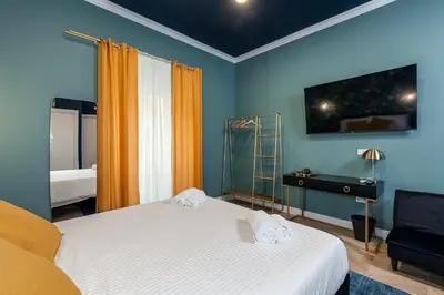 a bedroom with two beds and a desk in it at Suri Suites in Rome