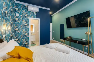 a bedroom with a large bed with a blue wall at Suri Suites in Rome