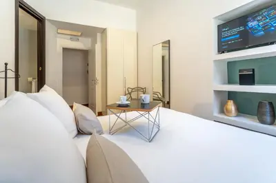 a pile of pillows on a bed with a table at PgrHome Croce in Rome
