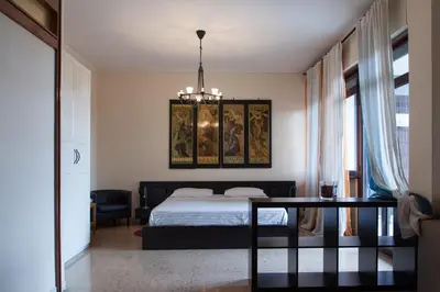 a bedroom with a bed and a table and a chandelier at Santa Croce in Rome