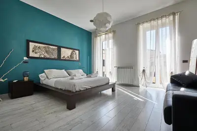 a bedroom with a bed and a blue wall at Apartment in front of St Peter's Square and Vatican Museums - myPad in Rome in Rome