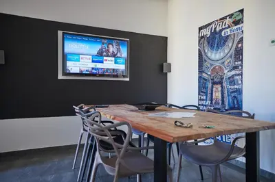 a table with chairs and a television on a wall at Apartment in front of St Peter's Square and Vatican Museums - myPad in Rome in Rome