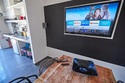 a video game controller on a wooden table with a television on a wall at Apartment in front of St Peter's Square and Vatican Museums - myPad in Rome in Rome