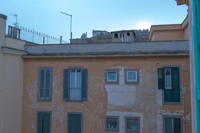 an orange building with green shutters on a building at Apartment in front of St Peter's Square and Vatican Museums - myPad in Rome in Rome