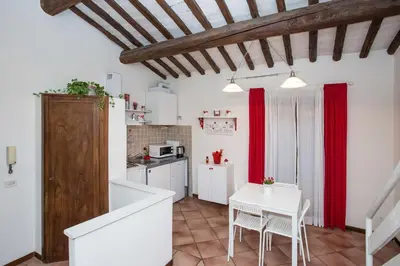 a kitchen with red curtains and a white table at Moro Magenta 1 Casa e Appartamento per Vacanze in Rome