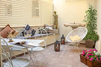 a patio with chairs and a table and a fountain at Casavignoni elegant 3BR home near to Spanish step in Rome