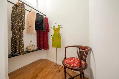 a room with a chair and clothes hanging on a wall at Casavignoni elegant 3BR home near to Spanish step in Rome