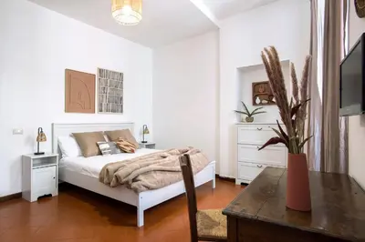 a white bedroom with a bed and a table at Trevi Fountain House Deluxe in Rome
