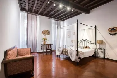 a bedroom with a canopy bed and a chair at Trevi Fountain House Deluxe in Rome