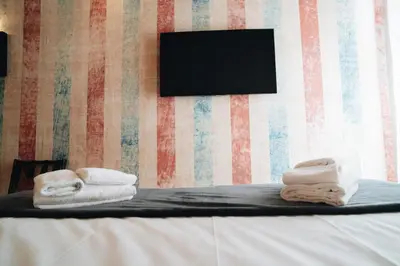 a room with towels on a bed with a television at DownTown Boutique House - CA Domus Collection in Rome