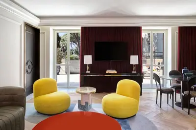 a living room with yellow chairs and a television at W Rome in Rome
