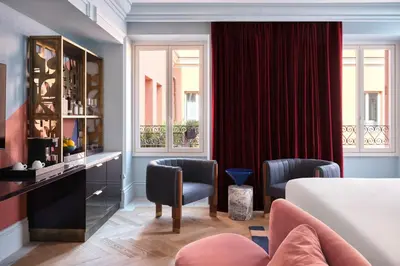 a hotel room with a bed and two chairs at W Rome in Rome