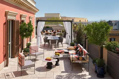 a patio with chairs and a table on a balcony at W Rome in Rome