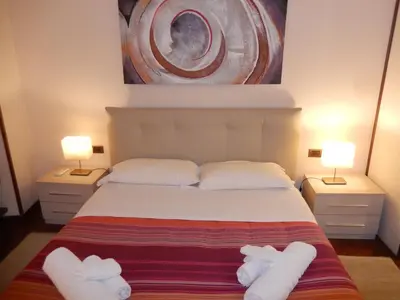 a bedroom with a bed with two white towels on it at Colosseo Homerents 2 in Rome
