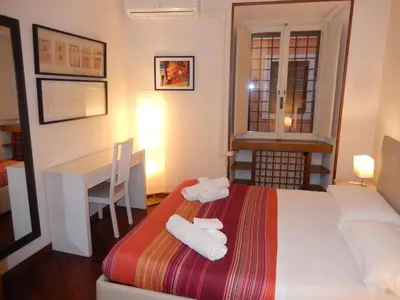 a bedroom with a bed and a desk and a table at Colosseo Homerents 2 in Rome