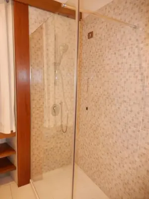 a shower with a glass door in a bathroom at Colosseo Homerents 2 in Rome