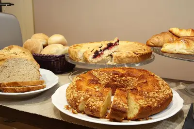 a table topped with different types of bread and pies at DG Prestige Room in Rome