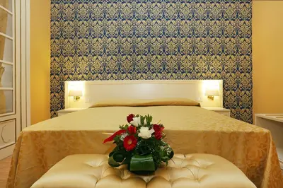 a bedroom with a bed with a bouquet of flowers at DG Prestige Room in Rome