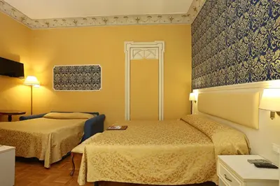 a hotel room with two beds and yellow walls at DG Prestige Room in Rome