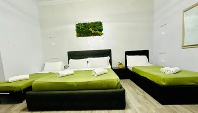 a bedroom with two beds with green sheets at Termini luxury home in Rome