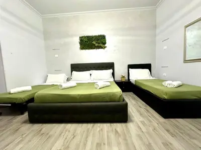 two beds in a room with green sheets at Termini luxury home in Rome