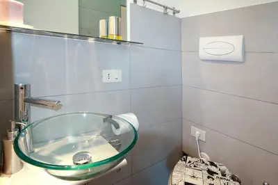 a bathroom with a glass sink on the wall at Light of Rome in Rome